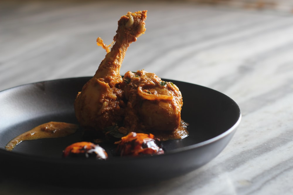 a black plate topped with food on top of a table