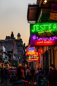 a group of people walking down a street next to tall buildings