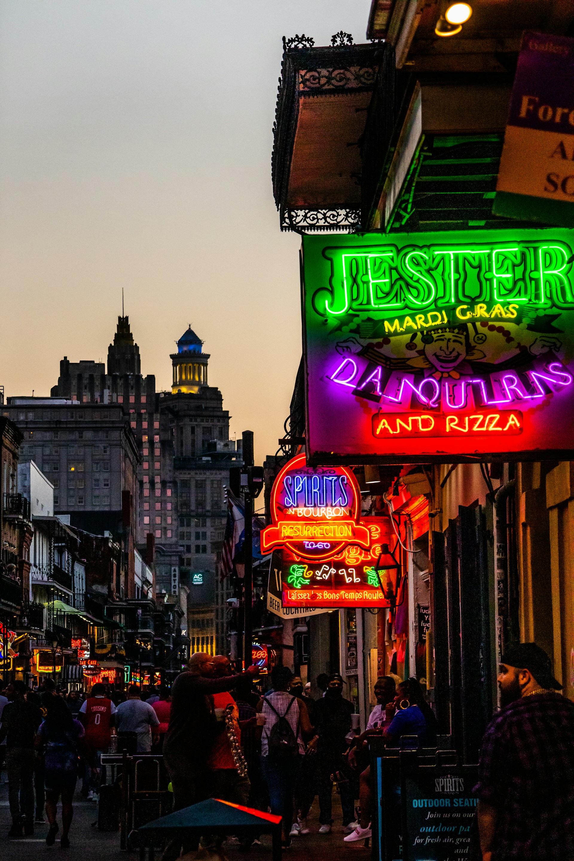 a group of people walking down a street next to tall buildings