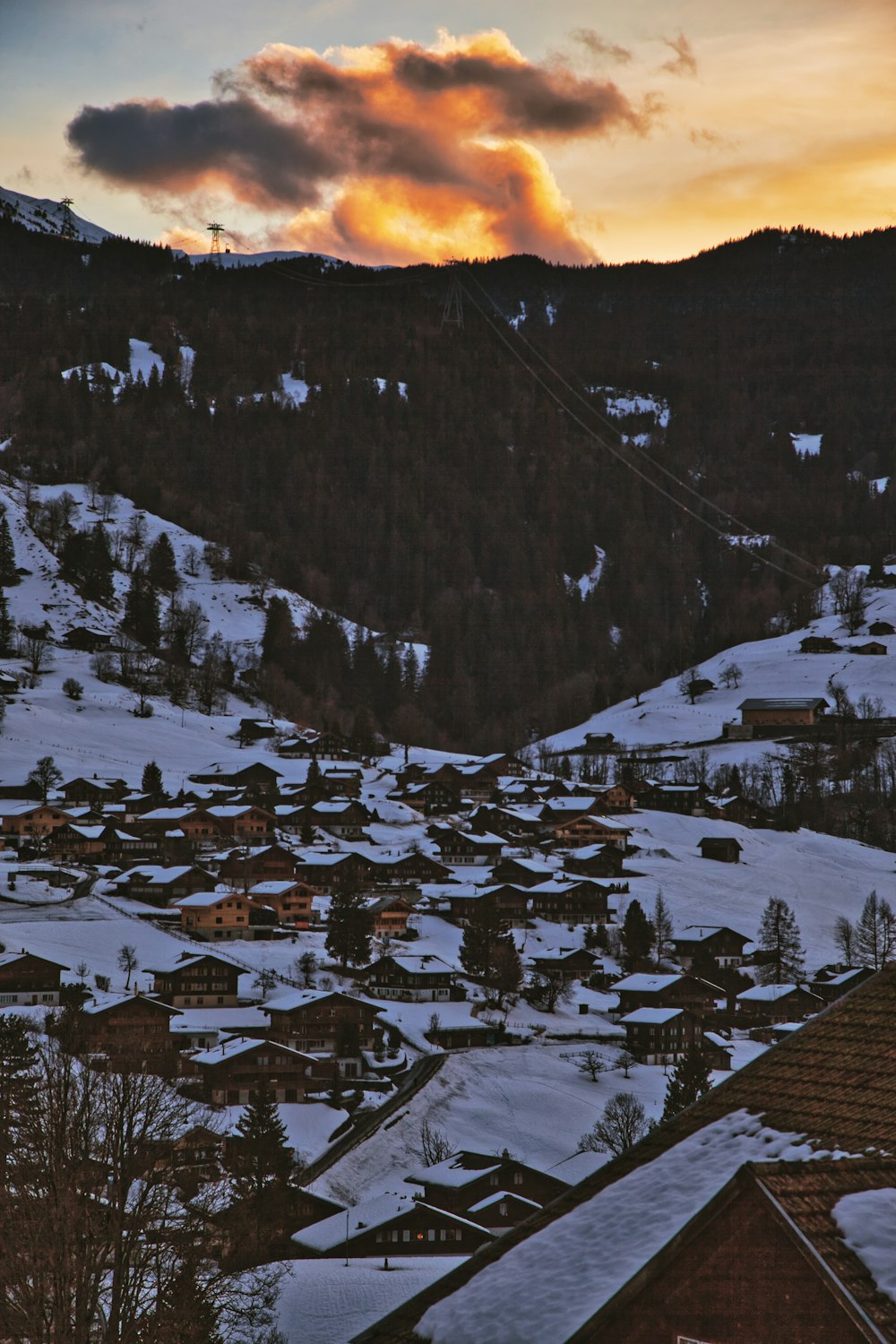 a snow covered town with a ski lift in the background