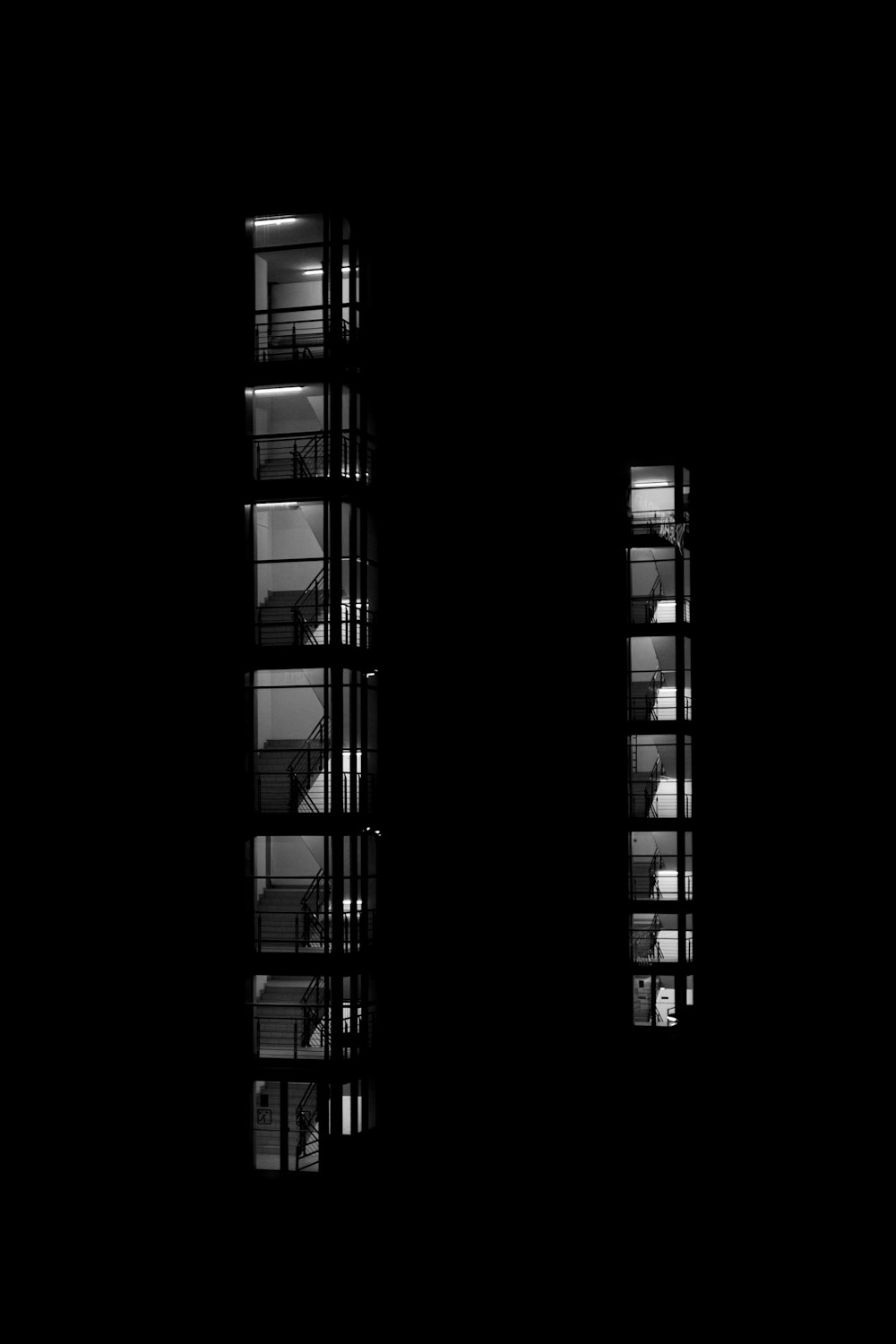 a black and white photo of windows in a dark room