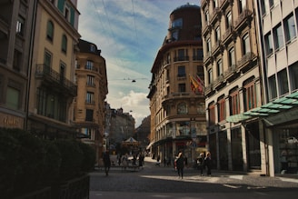a group of people walking down a street next to tall buildings