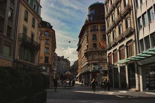 a group of people walking down a street next to tall buildings