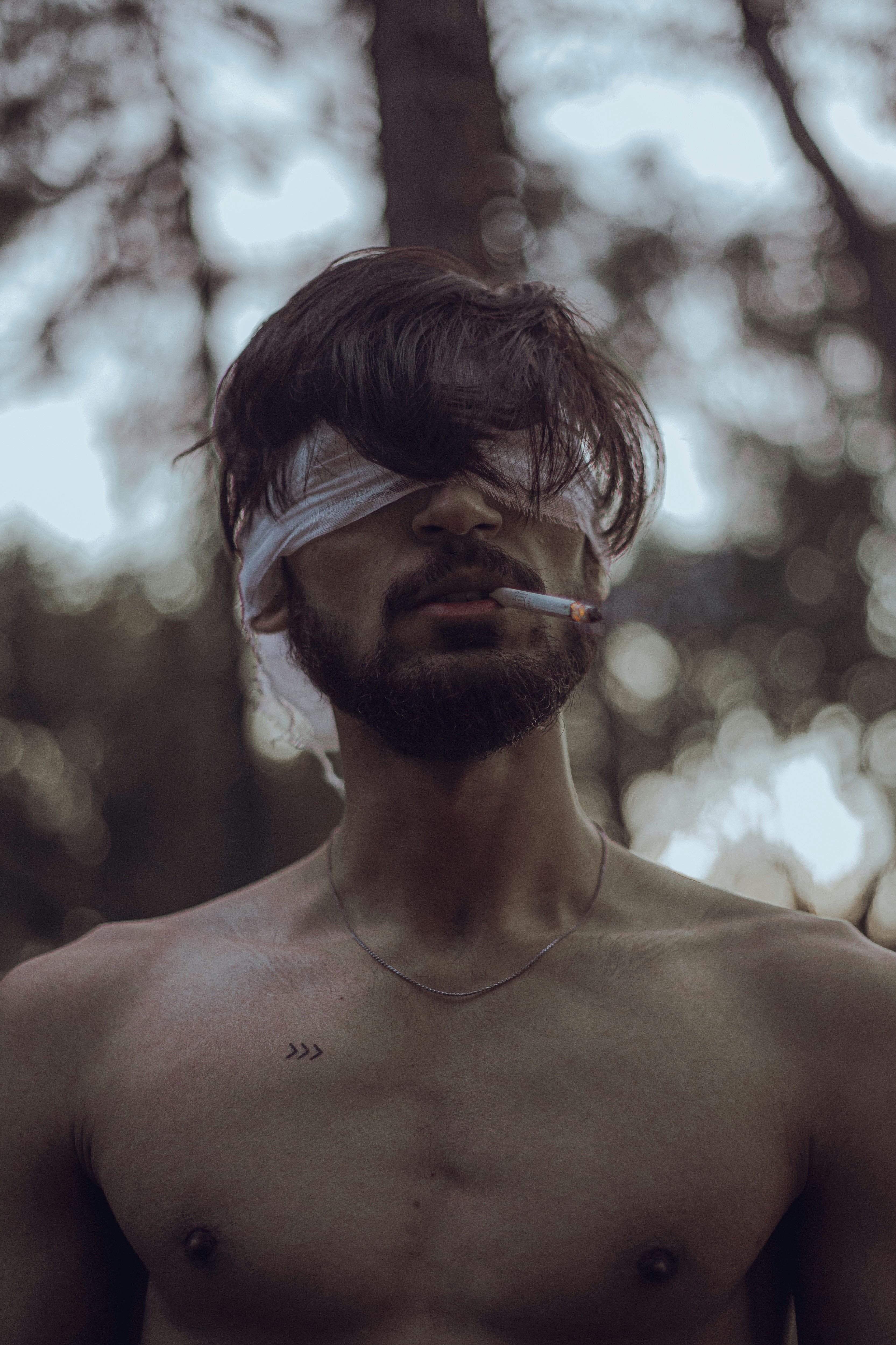 A man with a blindfold on his head smoking a cigarette photo – Free Grey  Image on Unsplash