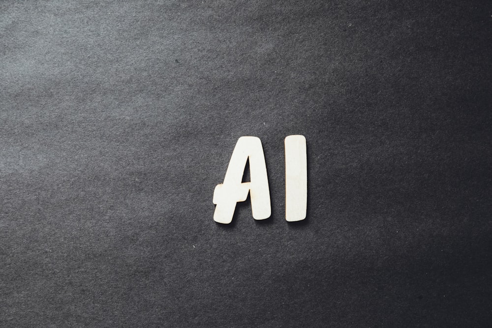 La palabra AI escrita en letras blancas sobre una superficie negra