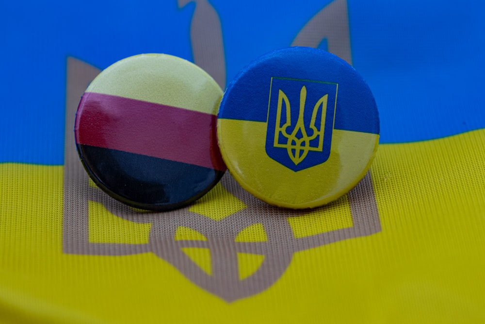 two buttons with the colors of the flag of ukraine and the coat of arms