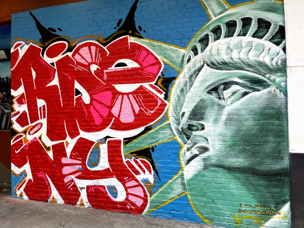 a mural of the statue of liberty painted on a brick wall