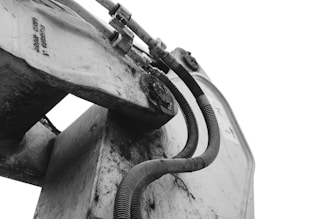 a black and white photo of a boat with a hose attached to it