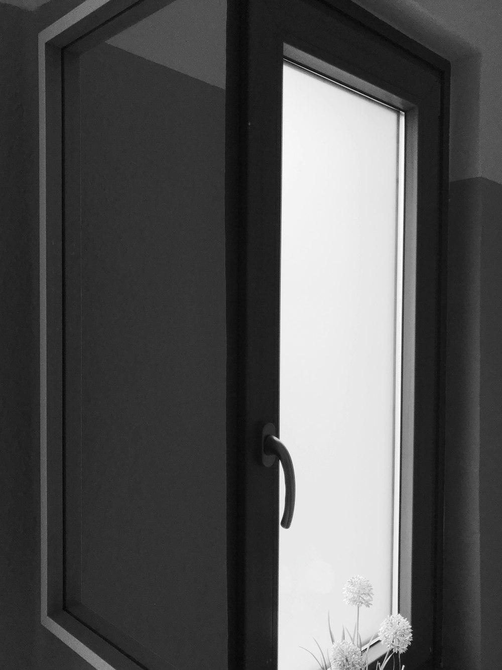 a black and white photo of a door and a window