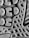 A close-up view of a textured surface, featuring a pattern of geometric shapes like circles and triangles. The material appears rubbery, with a detailed tread design suggesting it might be the sole of a shoe.