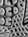A close-up view of a textured surface, featuring a pattern of geometric shapes like circles and triangles. The material appears rubbery, with a detailed tread design suggesting it might be the sole of a shoe.