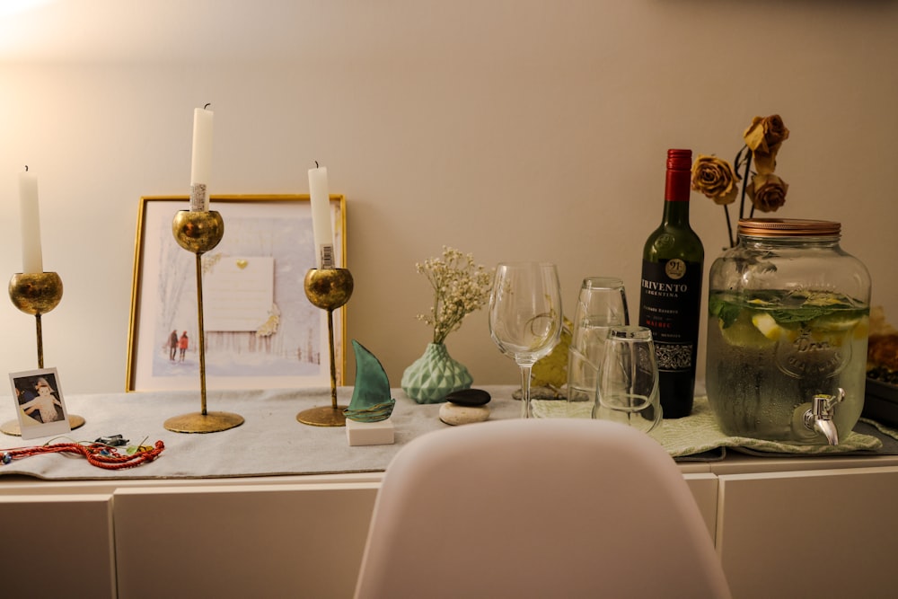 una mesa cubierta con copas de vino y una botella de vino