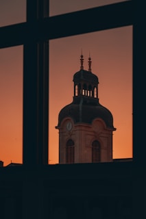 Photographer capturing the clock tower at sunset, highlighting its intricate details.