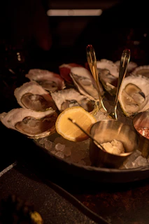 Artful arrangement of fresh oysters and shellfish on ice, glistening under soft golden light