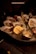 A close-up of a plate of glistening Limfjord oysters served with lemon wedges and rustic bread.