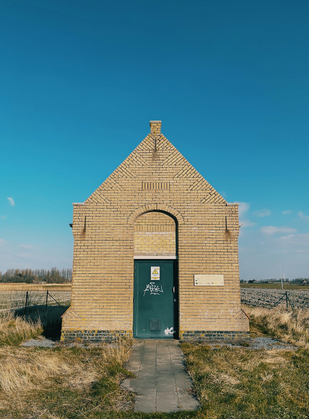 an old brick building with a green door