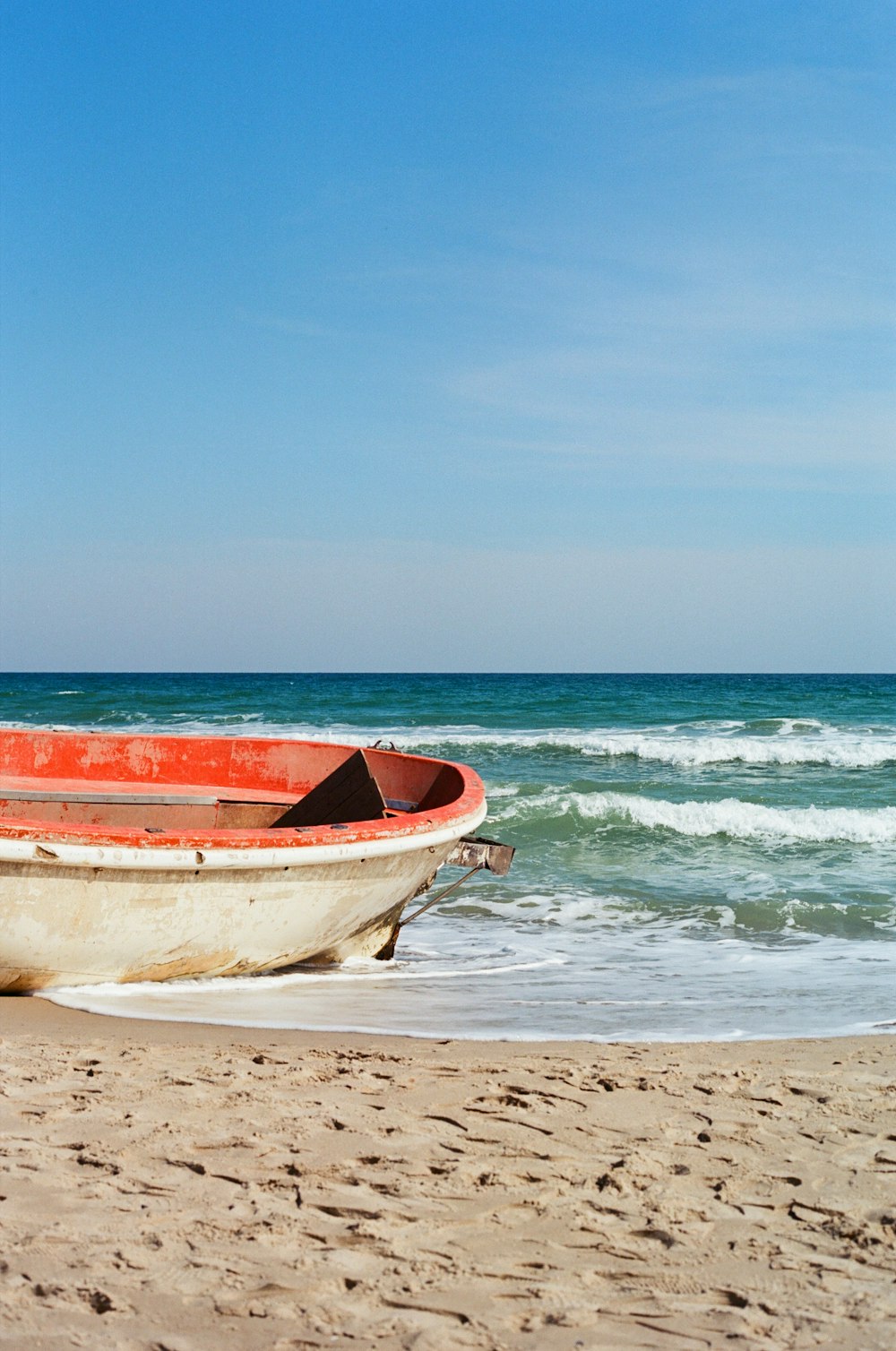 a boat sitting on top of a sandy beach