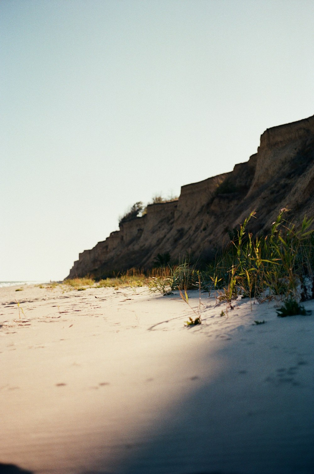 a person riding a surfboard on top of a sandy beach