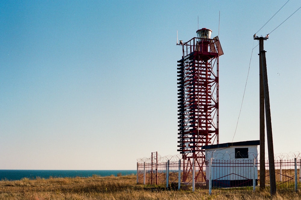 a tall tower sitting on top of a dry grass field