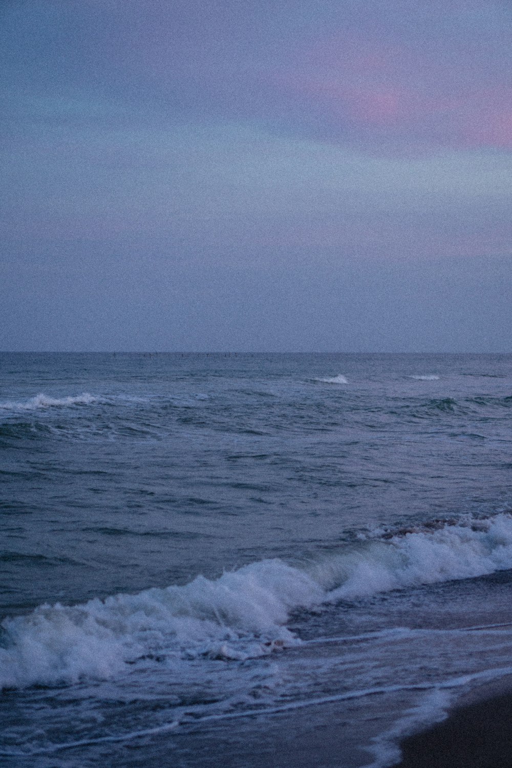 a person riding a surfboard on a wave covered beach