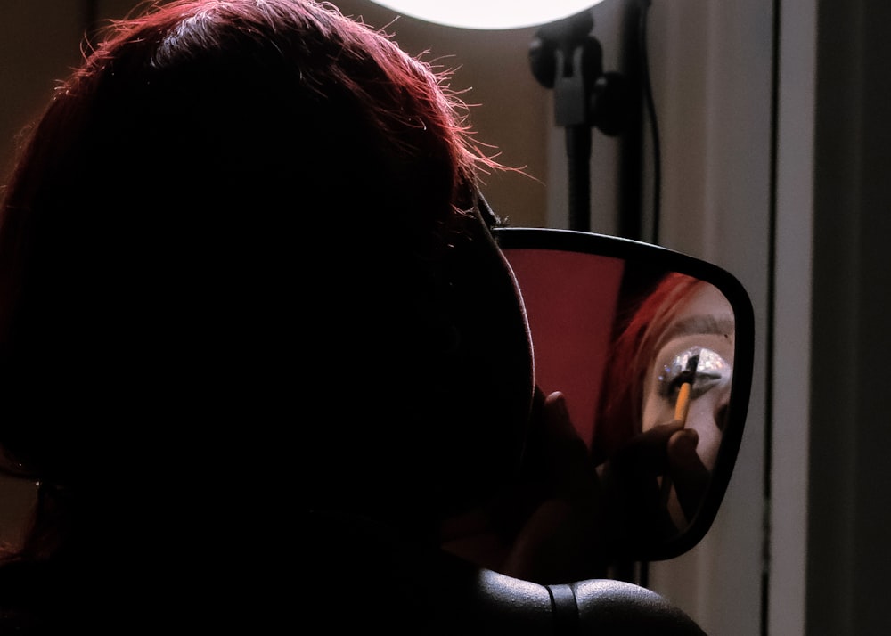 a woman is looking at her reflection in a mirror