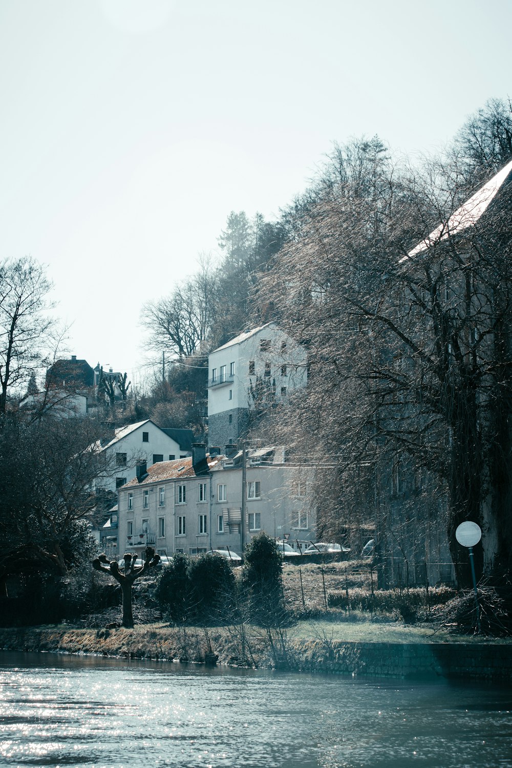 a body of water with houses on a hill in the background