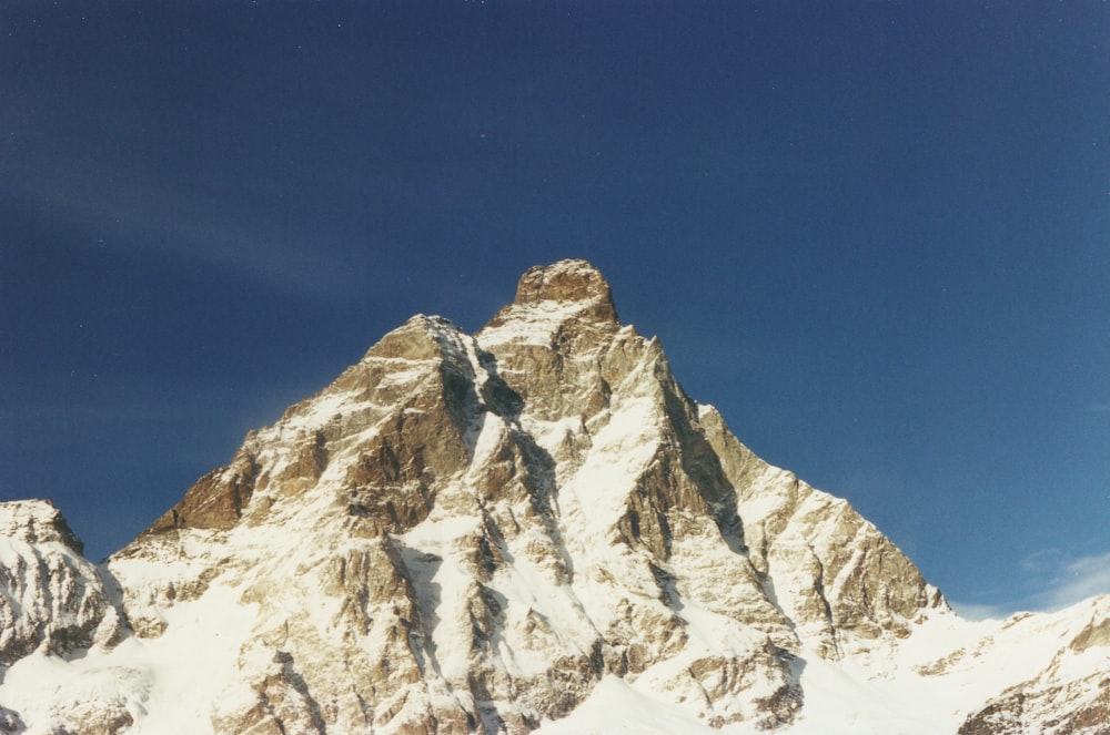 Ein Snowboarder steht vor einem verschneiten Berg