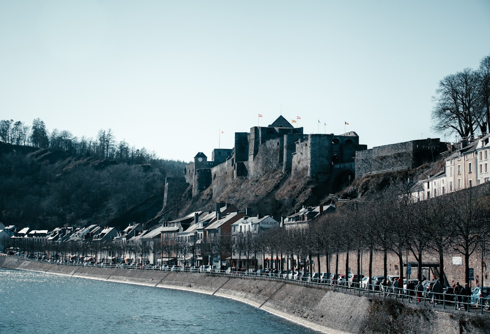a large castle sitting on top of a hill next to a river
