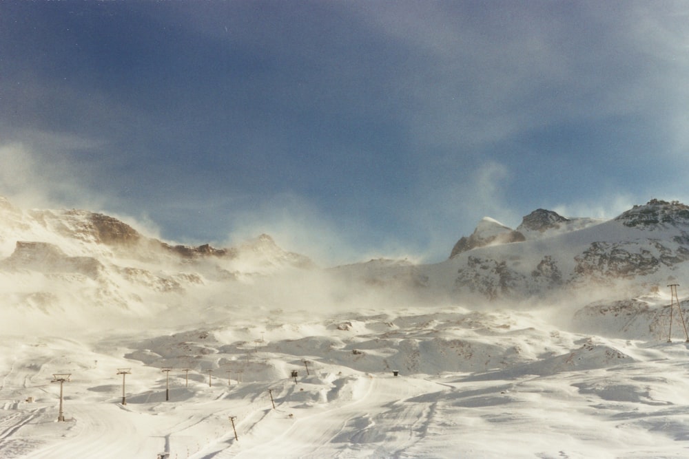 a snow covered mountain with a ski lift in the distance