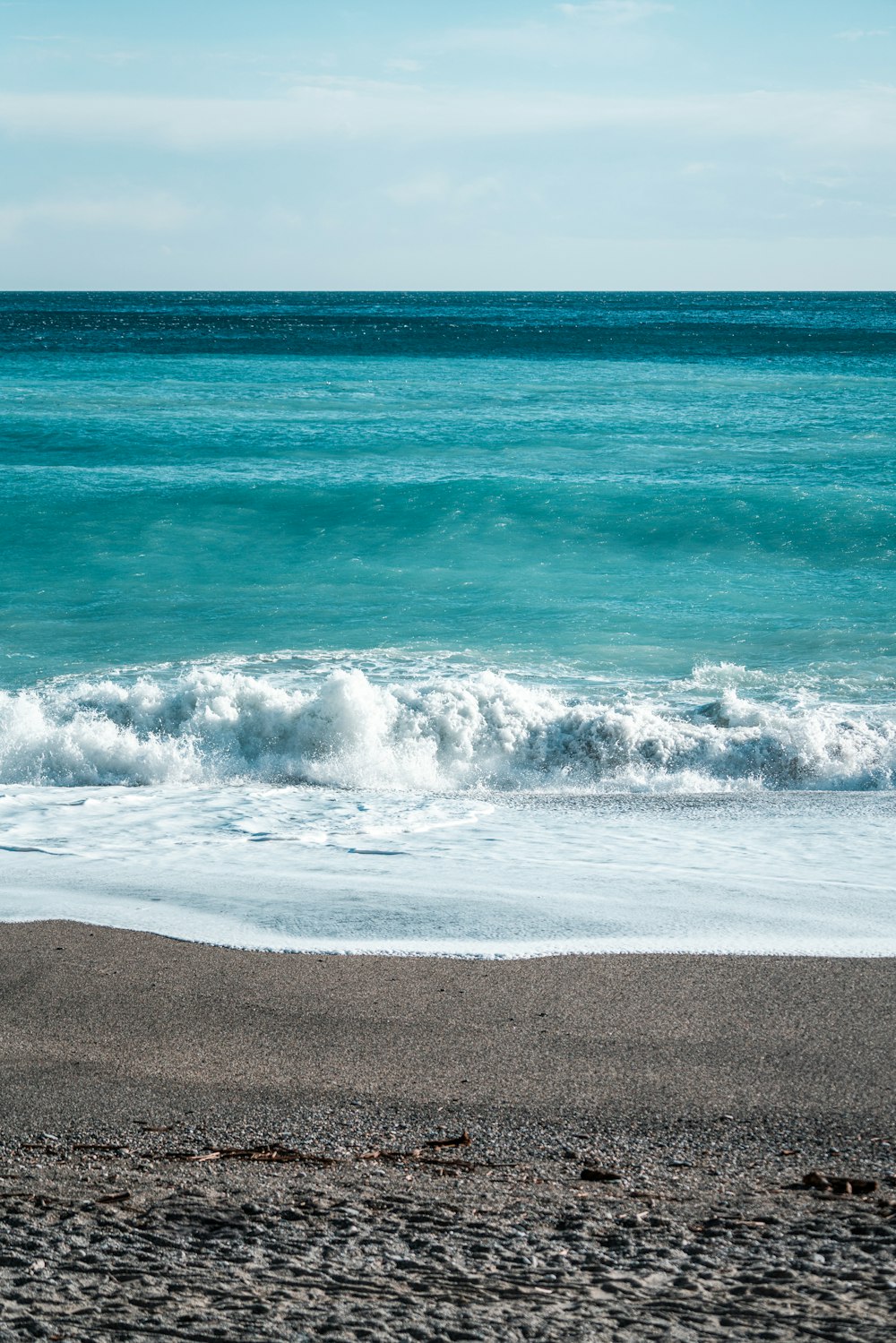 a person walking on the beach with a surfboard