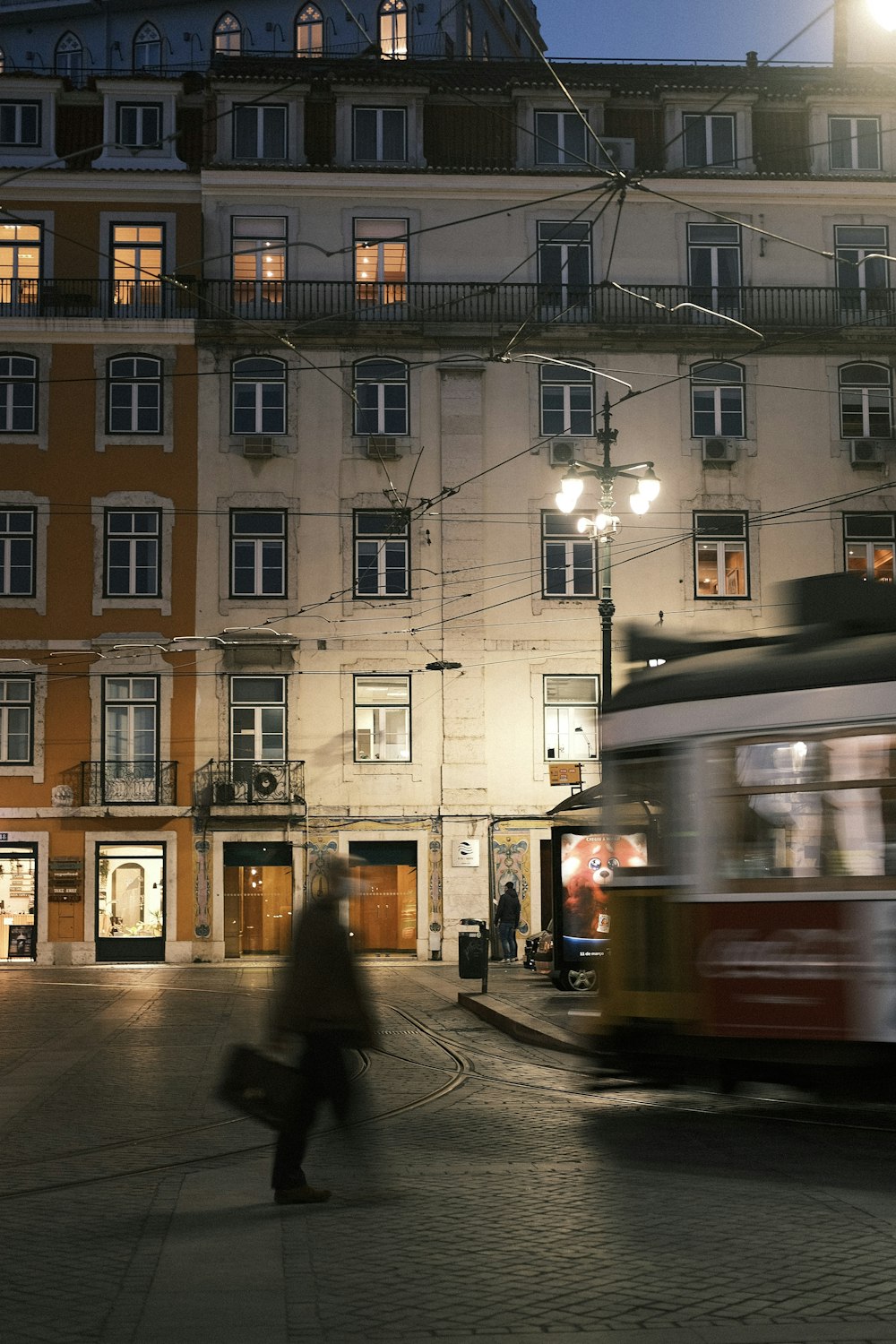 a trolley is passing by a building at night