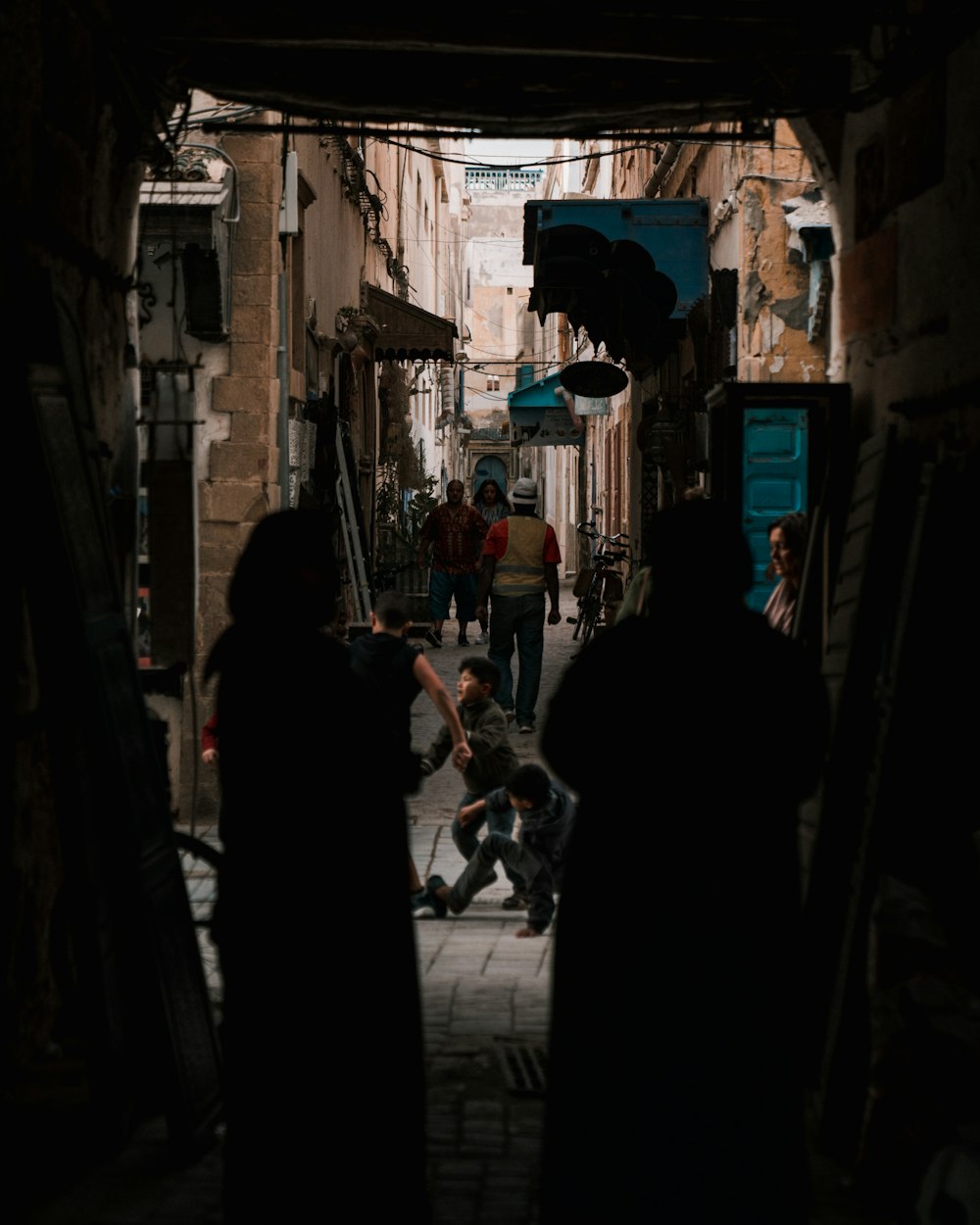 a group of people walking down a narrow alley way