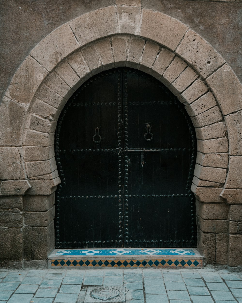 a large black door with a brick arch above it
