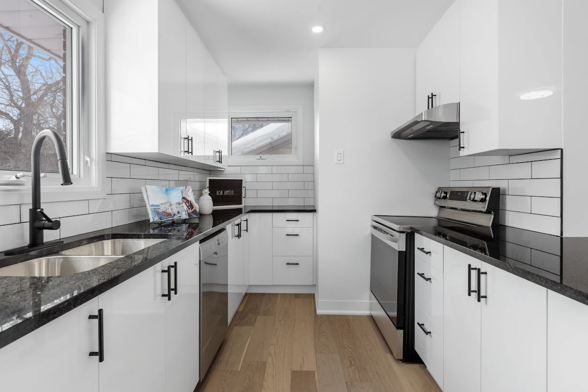 Renovated kitchen with white cabinets and a dark stone-look countertop, an example of standard-tier residential finishes