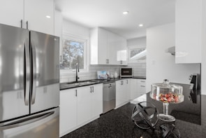 a kitchen with white cabinets and stainless steel appliances