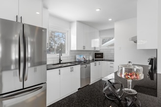 a kitchen with white cabinets and stainless steel appliances