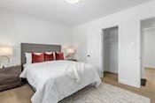 a bedroom with a bed, dresser, and closet