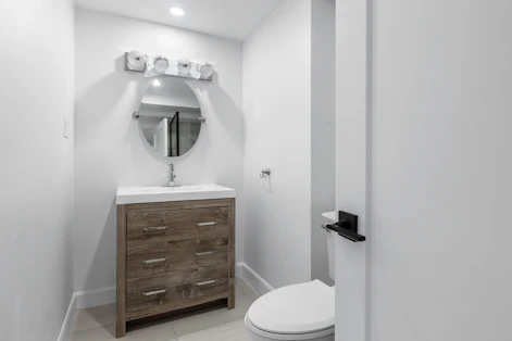 a white toilet sitting next to a bathroom sink
