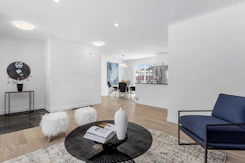 a living room filled with furniture and a painting on the wall