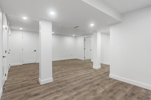 an empty room with white walls and wooden floors