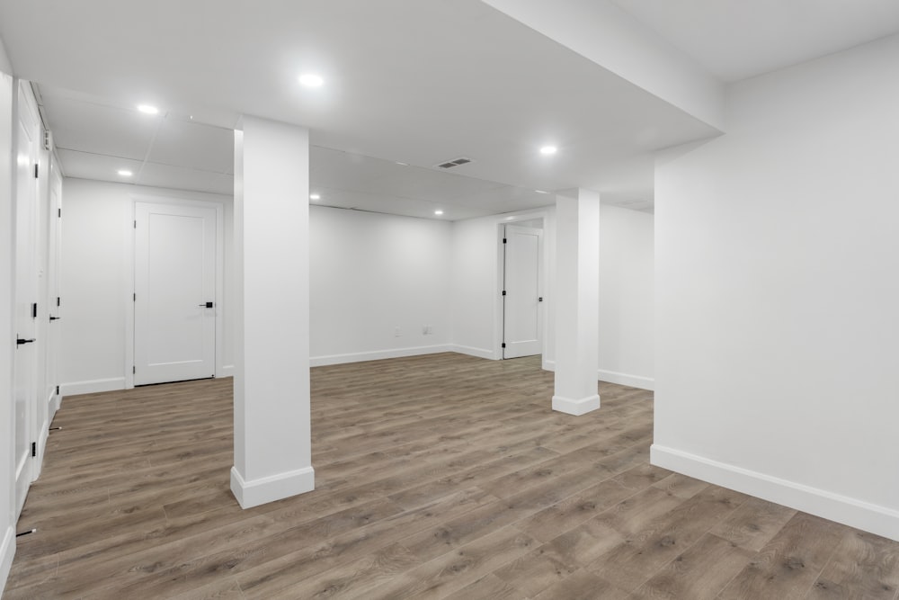 an empty room with white walls and wooden floors