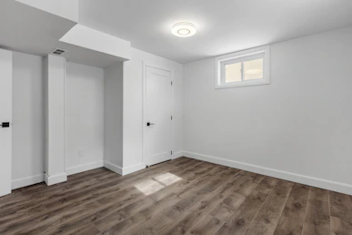 an empty room with white walls and wooden floors