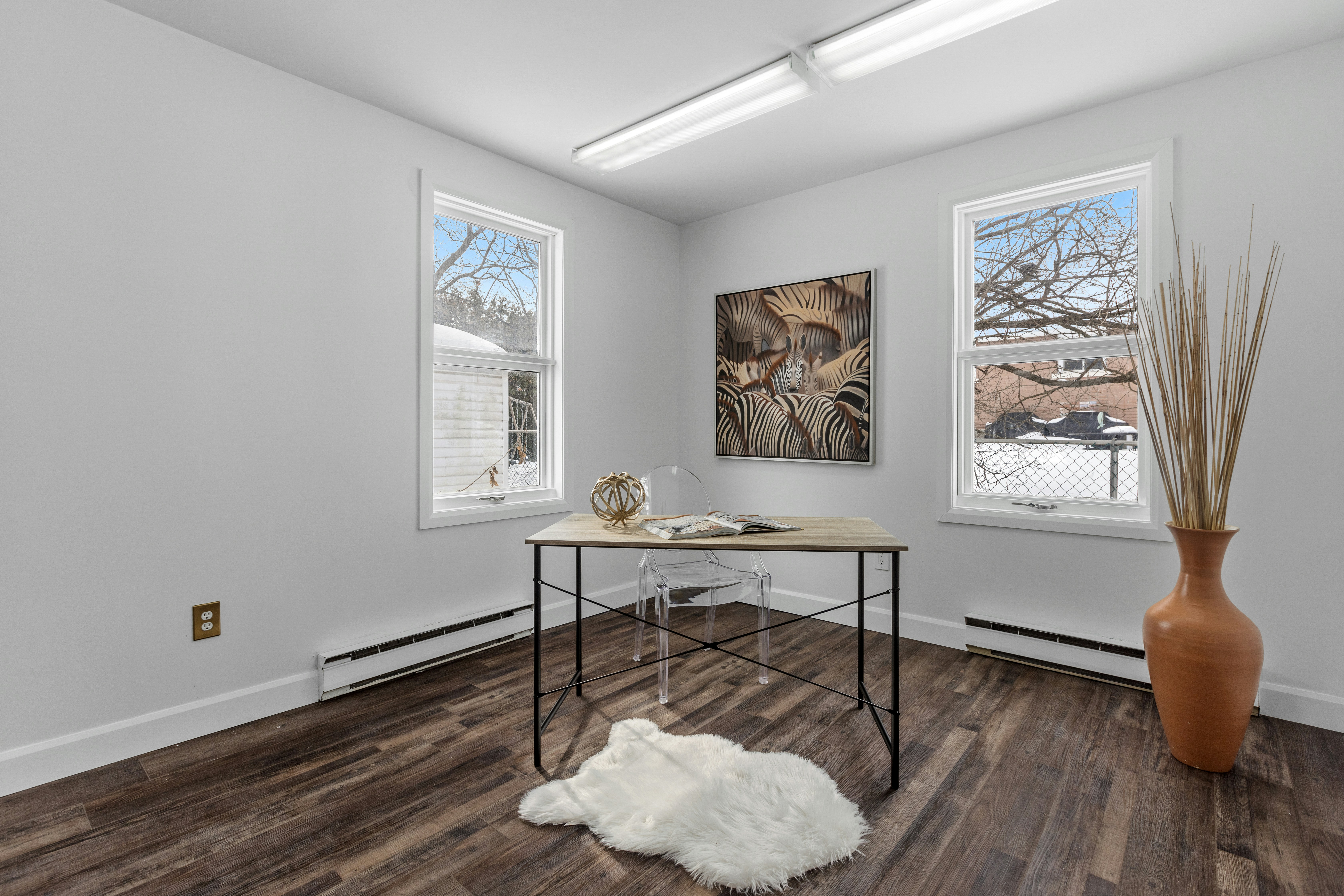 a room with a table and two windows