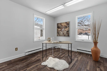 a room with a table and two windows
