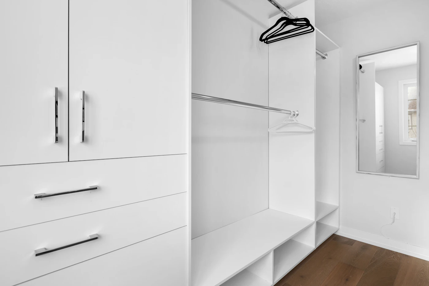 Organized walk-in closet with white cabinets and drawers