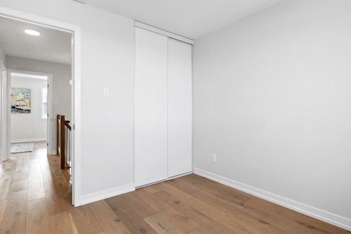 an empty room with white walls and wooden floors