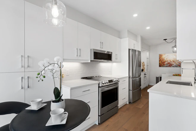 a kitchen with white cabinets and stainless steel appliances
