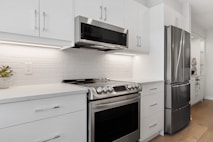a kitchen with white cabinets and stainless steel appliances