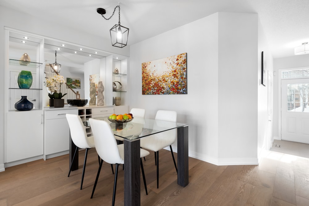 a dining room with a glass table and white chairs