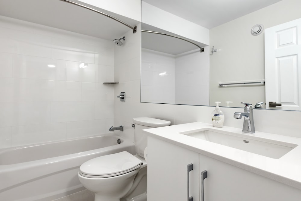 a white bathroom with a sink, toilet and bathtub